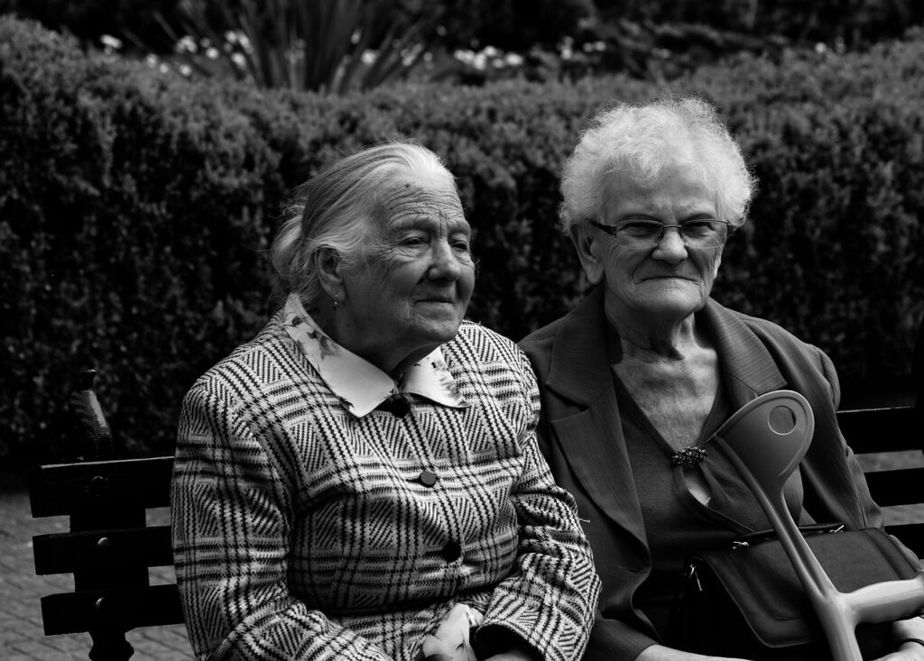 Two elderly women sitting in a garden