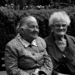 Two elderly women sitting in a garden